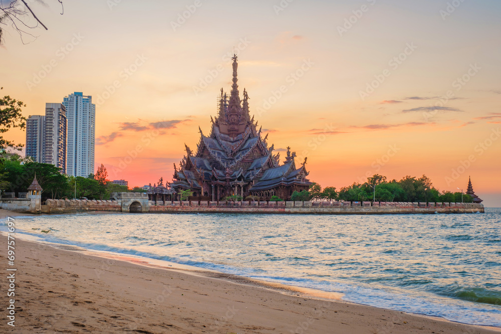 The Sanctuary of Truth wooden temple in Pattaya Thailand at sunset seen from the beach by the ocean