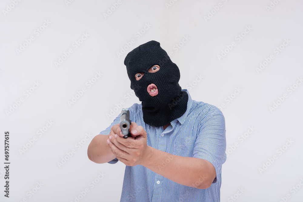 A scary and unhinged evil robber pointing a gun threatening to shoot. Commanding at gunpoint. Isolated on a white backdrop. A scary and unhinged evil robber pointing a gun threatening to shoot. Commanding at gunpoint. Isolated on a white backdrop.
