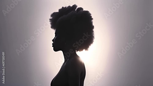 Beautiful portrait of proud African American black woman silhouette with afro curly hair on soft background. Copy space illustration of African American woman profile with afro ponytail hairstyle. Spa photo