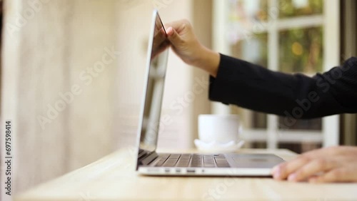 Women's hands open the laptop and lift its lid to start working at home close-up. Remote learning at home via a laptop webcam
