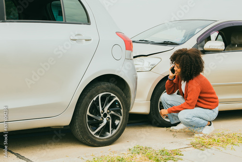 Картината върху платно African American woman with shocked expression drove recklessly crashing into the rear of the car and damaging the front Sitting distraught looking at the damage to her car there was no car insurance