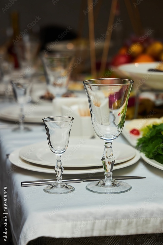 The setting of the festive table. Food and dishes. Festive glasses for drinks.