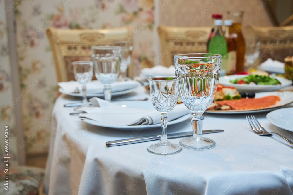 The setting of the festive table. Food and dishes. Festive glasses for drinks.