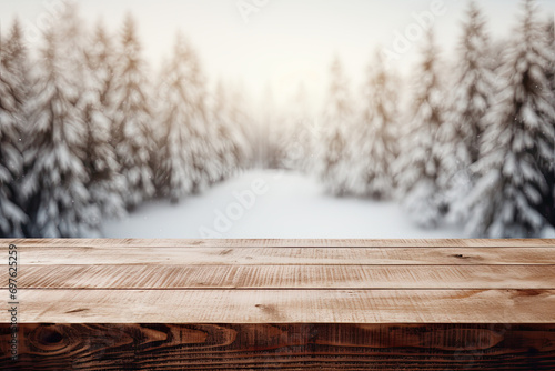 Empty wooden table with winter landscape with snow and christmas trees photo