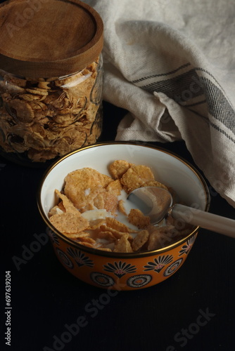 Bowl of cereal, cornflakes with milk in a bowl on a black background