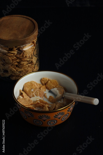 Bowl of cereal, cornflakes with milk in a bowl on a black background