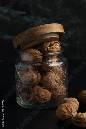 Walnuts in a glass jar on a black background