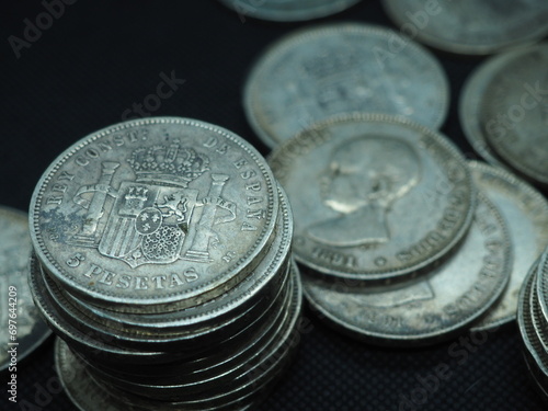 Five peseta coins, silver coins of Alfonso XIII on a black background photo