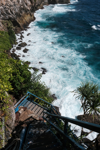 View from cliffside stairs leading to Pura Segara Kidul & Peguyangan hindu temple on sunny day. Nusa Penida, Indonesia. photo