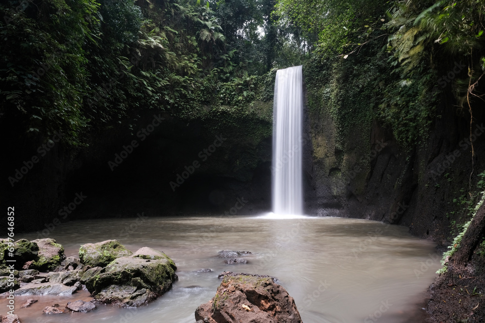 Obraz premium Long exposure shot of Tibumana waterfall on sunny day. Bali, Indonesia.