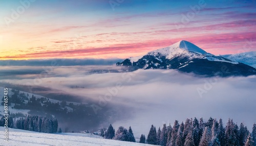 foggy winter sunrise in the snowy mountain