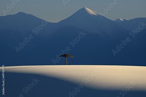 Mountains panorama in morning light with single wooden resort umbrella in a snow