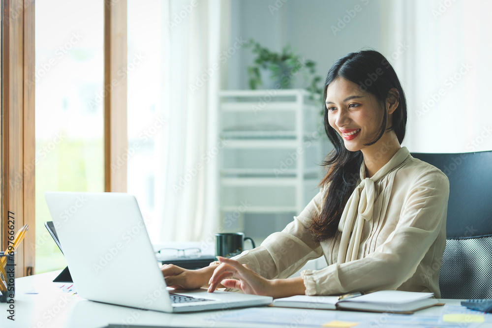 Portrait of happy young woman working on tablet pc while sitting at her working place in office. Portrait of happy young woman working on tablet pc while sitting at her working place in office.
