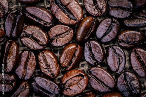 A pile of dark roast coffee beans, a blend of Arabica and Robusta. Caffeine in coffee is a drug that stimulates the brain and nervous system. photo