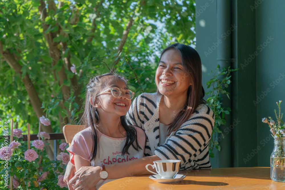 Head shot portrait smiling loving mother hugging adorable little daughter, caring happy mum and cute girl enjoying tender moment, sitting on cozy couch Head shot portrait smiling loving mother hugging adorable little daughter, caring happy mum and cute girl enjoying tender moment, sitting on cozy couch