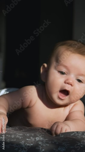 Beautiful caucasian baby infant learning to lie on his stomach and smiling. Close-up portrait