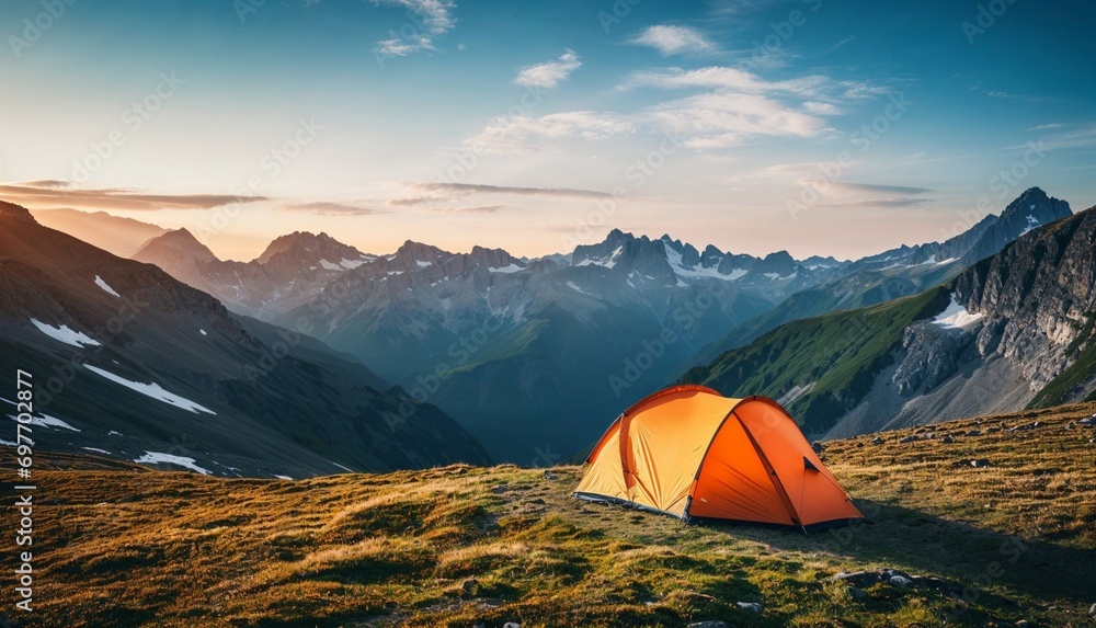 Camping orange tent high in the mountains at sunrise. Camping in the mountains.