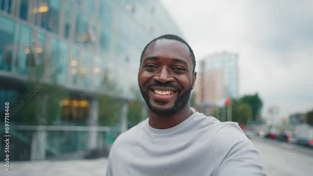 Man has video call on street in phone. Positive african american smiling bearded guy talking with friend relative looking at camers standing outdoors in city. Online communication, chatting concept. Man has video call on street in phone. Positive african american smiling bearded guy talking with friend relative looking at camers standing outdoors in city. Online communication, chatting concept.