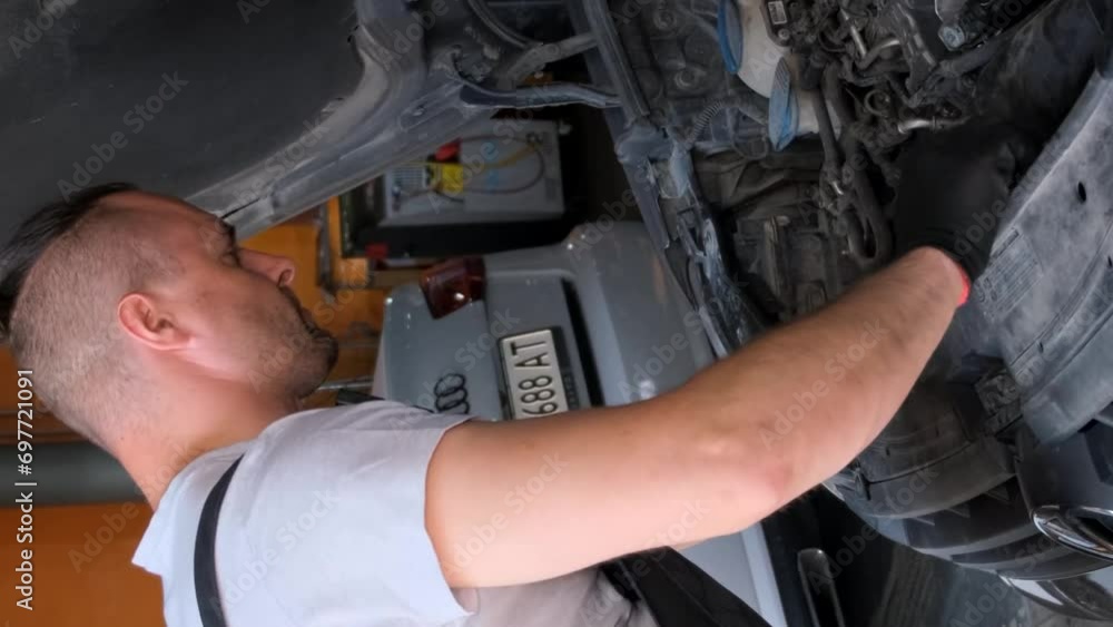 Mechanic working on car engine in garage workshop, concept of car service and car maintenance. Vertical video Mechanic working on car engine in garage workshop, concept of car service and car maintenance. Vertical video