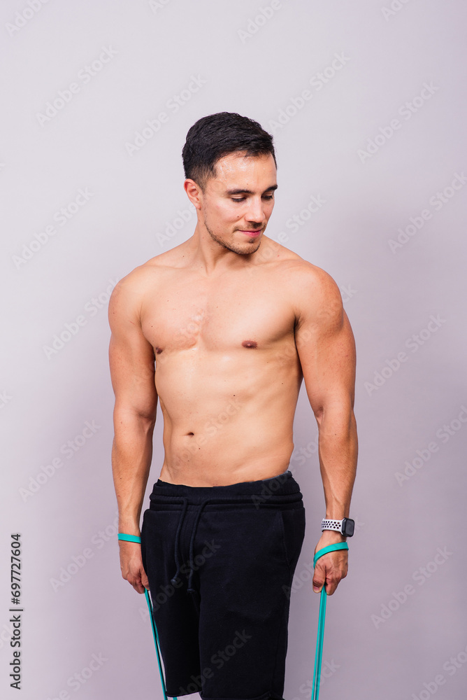 Athletic man skipping with a jump rope on grey background. Best cardio workout Athletic man skipping with a jump rope on grey background. Best cardio workout