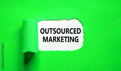 Outsourced marketing symbol. Concept words Outsourced marketing on beautiful white paper. Beautiful green paper background. Business Outsourced marketing concept. Copy space.