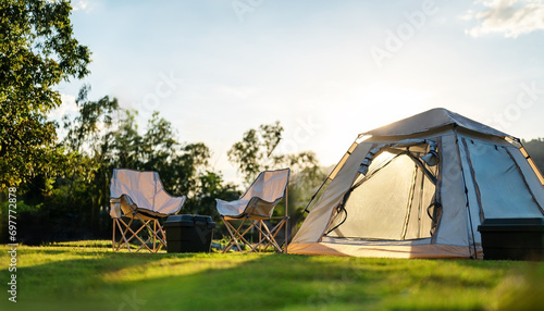 nature, tent, camp, vacation, adventure, campground, grass, trip, campfire, camping. selective focused on lawn or green grass ground of camping ground, with camping tent in background and sunlight. © Day Of Victory Stu.