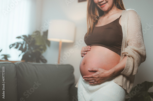 mother, family, maternity, pregnant, woman, pregnancy, baby, motherhood, love, happiness. pregnancy, motherhood, people, close up of happy pregnant woman with big belly near stand sofa and smiling. Free Download mother, family, maternity, pregnant, woman, pregnancy, baby, motherhood, love, happiness. pregnancy, motherhood, people, close up of happy pregnant woman with big belly near stand sofa and smiling. - GFXLoad