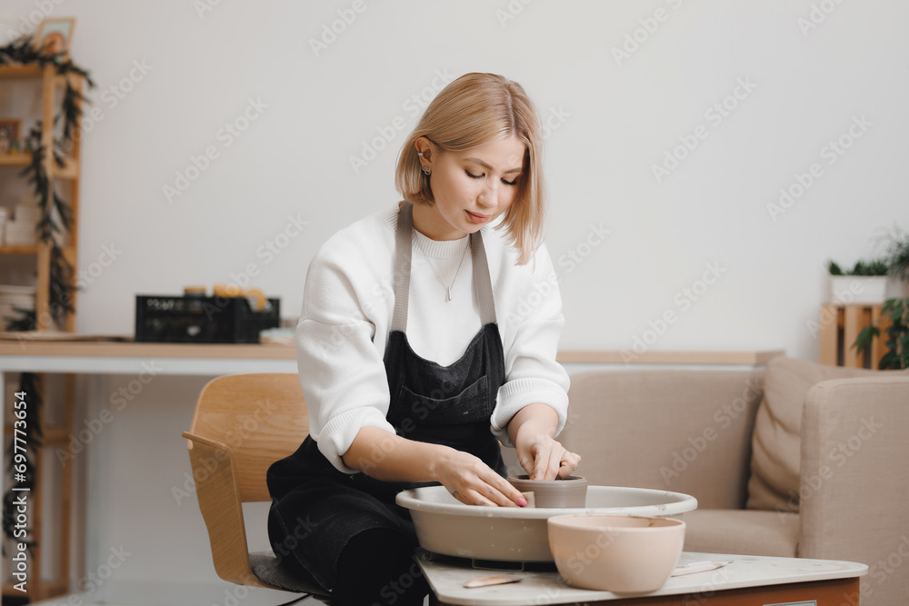 Happy young woman on potter wheel makes clay dishes, relax DIY business. Happy young woman on potter wheel makes clay dishes, relax DIY business.