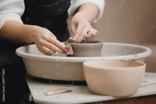 Hands young woman with manicure master on potter wheel makes clay dishes, relax DIY business.