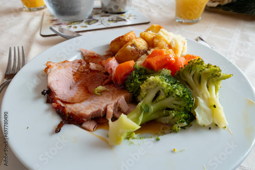 Fotografija A dinner of home cooked roast gammon with potatoes, broccoli and carrots