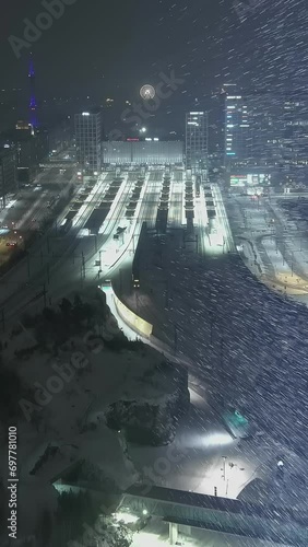 Helsinki.Finland-December 31.2021: Drone shot of the railway station in Pasila Helsinki during snowfall. Nighttime. Wintertime. Amazing cityscape. Camera slowly moving backwards.Vertical Format Video. photo