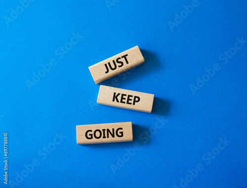 Just keep going symbol. Concept words Just keep going on wooden blocks. Beautiful blue background. Business and Just keep going concept. Copy space.