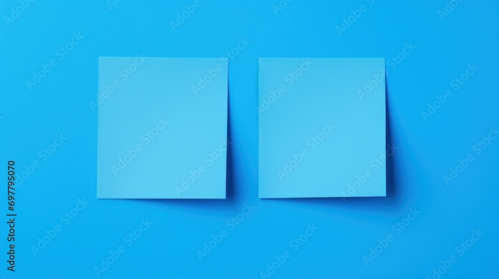 two pieces of paper sitting on top of a blue surface with one piece of paper on top of the other. two pieces of paper sitting on top of a blue surface with one piece of paper on top of the other.