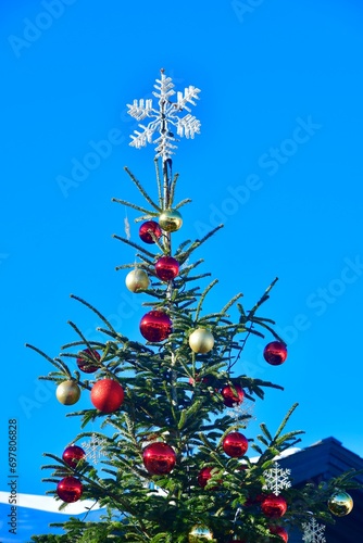 Outdoor Decorated Christmas tree with blue sky background 