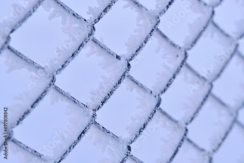 Mesh of chain link covered with frost after severe frost. Macro photography.