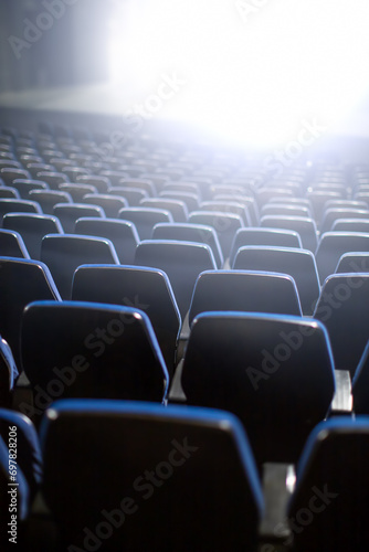 empty theater seats with bright wight light coming from stage