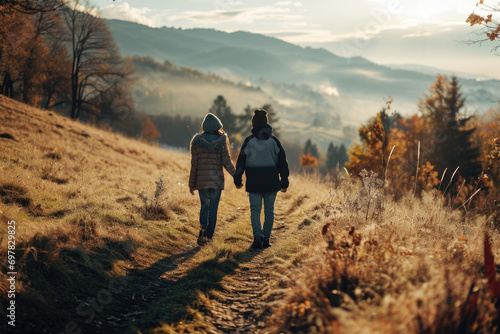 A picture capturing two people walking down a scenic path in the mountains. This image can be used to depict outdoor activities, adventure, and exploration © Fotograf