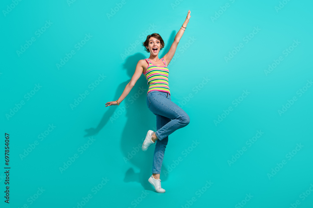 Obraz premium Full size photo of astonished positive girl raise hands rejoice have good mood isolated on teal color background