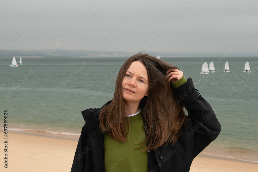 Portrait of a beautiful young woman with long brown hair on the beach Portrait of a beautiful young woman with long brown hair on the beach