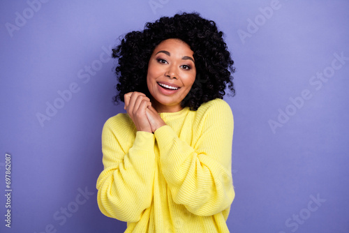 Portrait of good mood person with afro hairstyle wear knit pullover hold hands together near cheek isolated on purple color background © deagreez