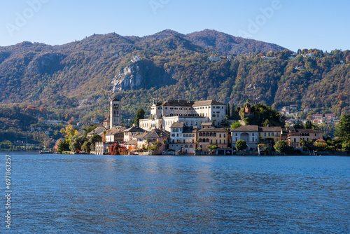 San Giulio Island within Lake Orta in Piedmont, Italy. colorful mountains in autumn, blue water and buildings