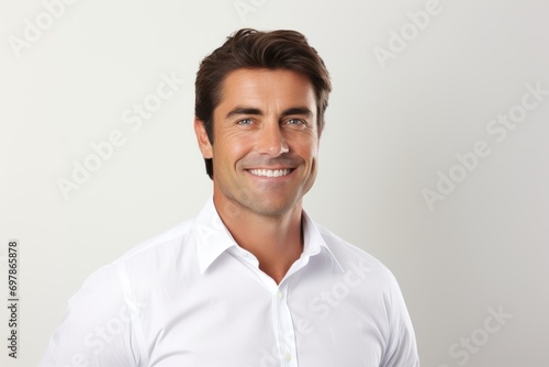 Portrait of a handsome young man in white shirt smiling at camera