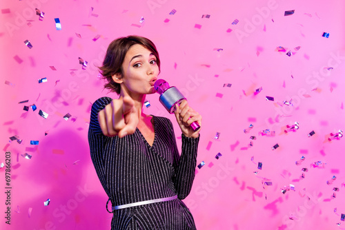 Photo of cheerful funky lady wear glamour outfit hosting concert pointing finger you isolated vivid pink color background photo