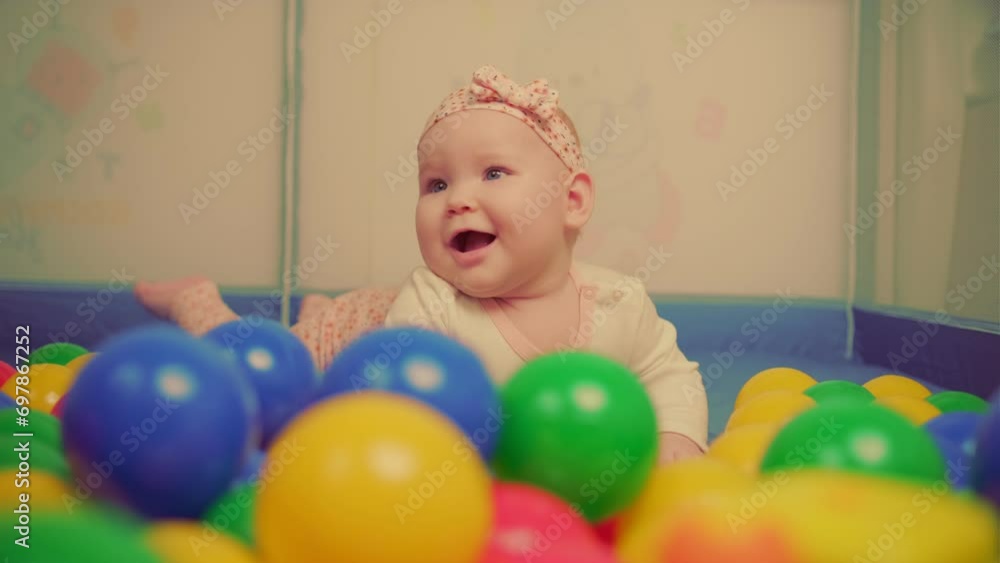 Cute baby girl playing with colorful balls in kindergarten. Cute baby girl playing with colorful balls in kindergarten.