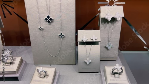 Rings, earrings and pendants on chains made of white gold or silver are displayed in the window of a jewelry store