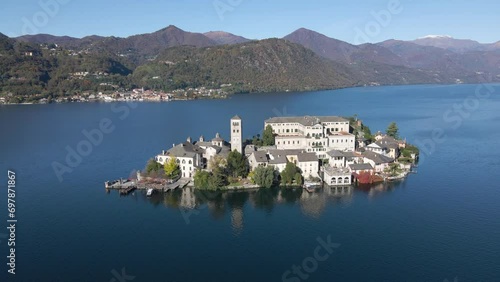 San Giulio Island within Lake Orta in Piedmont, Italy. aerial drone view in autumn. mountains, blue water and reflection photo