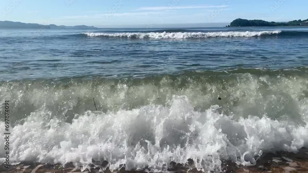 Summer. Sea shore. A wave hits the coastal sand. The video contains wave noise.