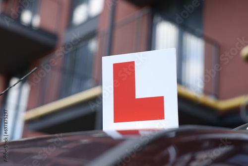 L-plate on car roof outdoors. Driving school photo