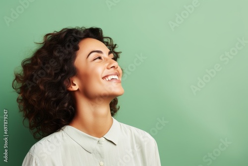 Portrait of a beautiful smiling woman with curly hair over green background