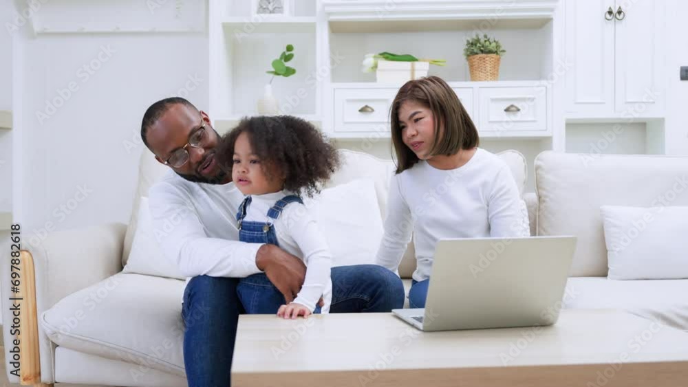 Happy african family parents and little children enjoy using computer laptop together sit on sofa, technology addicted couple with kids having fun at home Happy african family parents and little children enjoy using computer laptop together sit on sofa, technology addicted couple with kids having fun at home